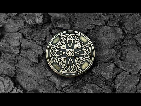 Custom engraved Celtic brass amulet on a dark bark background, authentic Viking and Celtic style souvenir.