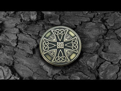 Custom engraved Celtic brass amulet on a dark bark background, authentic Viking and Celtic style souvenir.