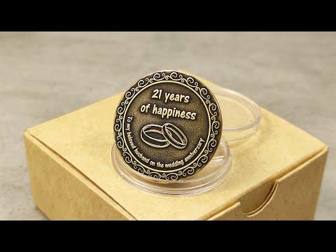 Product video of custom engraved brass anniversary coin in a protective capsule and premium kraft paper gift box.