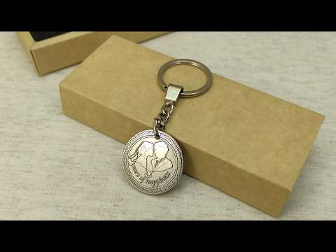 Stainless steel anniversary coin keychain placed on a craft gift box, durable metal personalized gift for 11th steel wedding anniversary celebration.